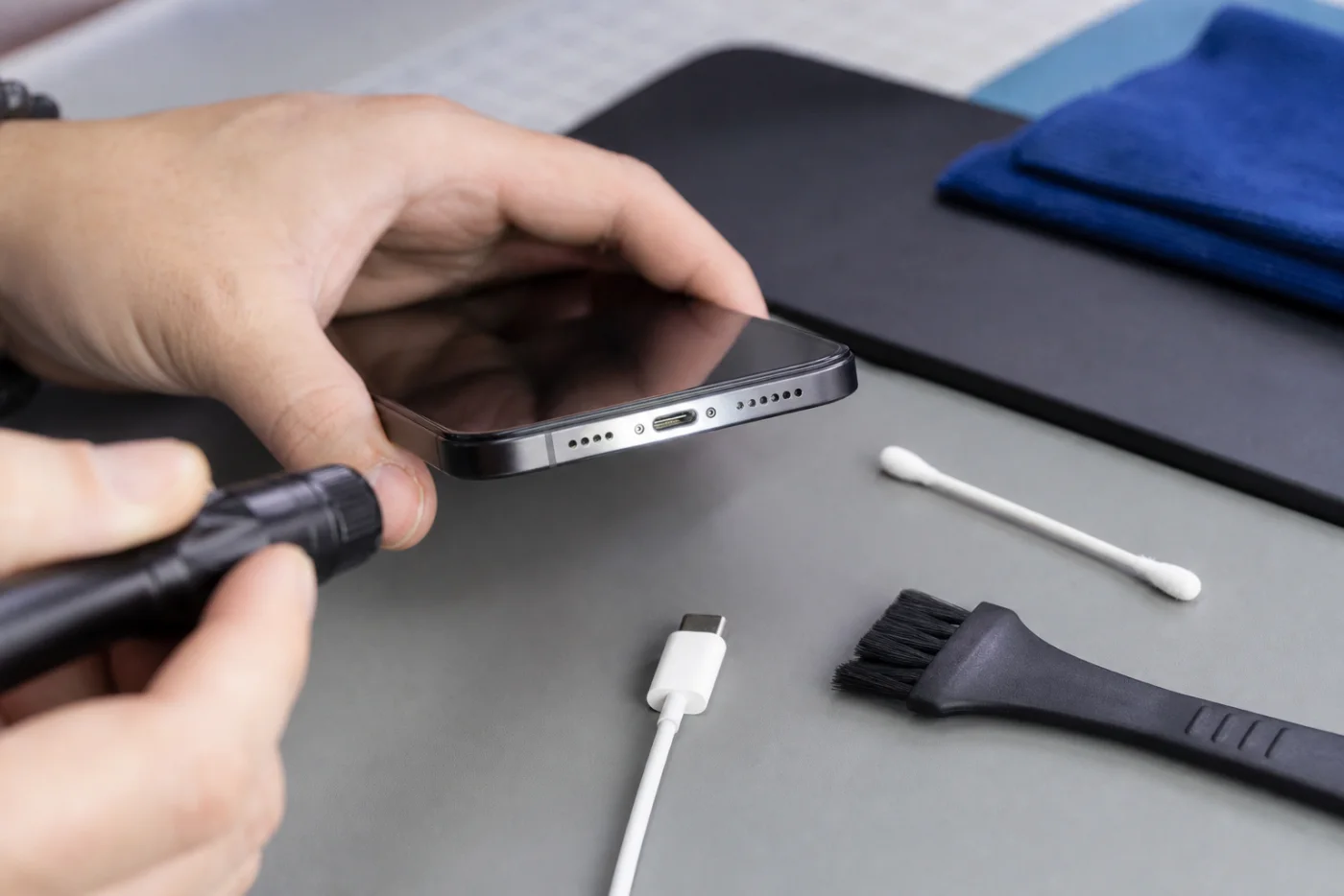 Contrôle du connecteur de charge iPhone avec lampe, câble et brosse douce