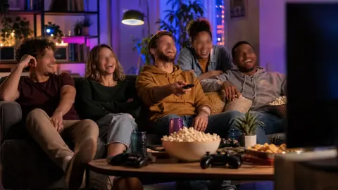 Soirée film comique entre amis dans un salon geek